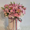 Pink floral arrangement in a round hat box with ribbon bow