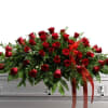 A classic cascade of deep red roses arranged in a large, low