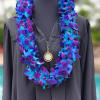 Blue orchid blooms form a lush, double-stranded lei that reads like celebration