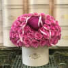 Pink roses arranged around a glittery heart in a white hat box