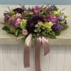Lavender roses, purple dahlias, stock blooms, green hydrangeas and mums with accents