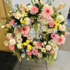 Large floral wreath with pink, cream, yellow, and blue flowers