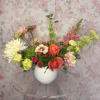 Mixed bouquet in a white vase with pink, orange, and white blooms