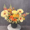 Colorful mixed bouquet in a dark vase with gerberas and roses