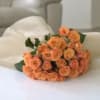 Bouquet of peach spray roses wrapped in white paper