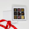 Box of assorted chocolates with a red ribbon and card