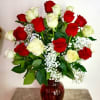 Red and white roses in a red glass vase