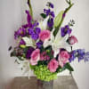 Bouquet of pink roses, white lilies, and purple flowers in a vase