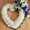 Heart-shaped white floral wreath with roses and lilies