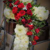 Cross-shaped floral arrangement of red roses and white chrysanthemums