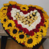 Heart-shaped arrangement of red and white roses with sunflowers and gold chocolates
