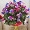 Bouquet of multicolored roses in a gold vase with pink ribbon