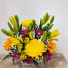 Basket arrangement of yellow lilies, chrysanthemums, and purple daisies