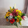 Colorful floral centerpiece with a tall candle in the middle