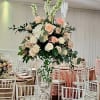 Tall floral centerpiece with blush and white roses in a clear vase