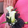 White calla lily corsage with black ribbon on a wrist