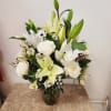 White lilies and roses arranged in a glass vase