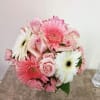 Pink roses and gerbera daisies in a compact bouquet