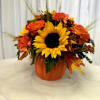 Sunflower and orange floral arrangement in a pumpkin container