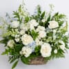 Large white and pale blue flower arrangement with roses in a wicker basket