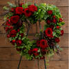 Heart-shaped wreath of red roses and greenery on a stand