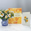 Pop-up bouquet of yellow and white daffodils in a blue patterned pot with a card
