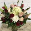 Bouquet of red and blush roses with white hydrangea in a glass vase