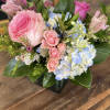 Pink roses and blue-white hydrangeas in a glass vase