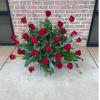 Arrangement of red roses with greenery on the ground