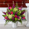 Pink roses and purple flowers arranged in a white vase