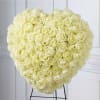 Large heart-shaped bouquet of pale cream roses on a stand