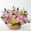 Pink lilies, roses, and carnations in a pumpkin-shaped basket