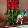 Red roses in a white hatbox with a teddy bear and anniversary tag
