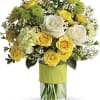Bouquet of yellow and white roses with green mums in a glass vase