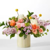 Mixed bouquet of roses and pastel flowers in a gold ribbed vase