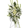 White and pale yellow funeral spray on a standing easel