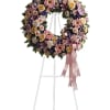 Floral wreath on a white easel with a pink ribbon bow