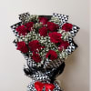 Bouquet of red roses and white baby's breath wrapped in black-and-white patterned paper