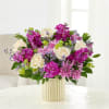 Creamy white roses set against vivid purple stock-like blooms and soft pink