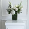 White floral arrangement in a clear rectangular vase