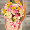Large bouquet of pink, white, yellow, and red flowers in a pink hat box