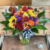 Colorful mixed bouquet in a glass vase with a plaid ribbon