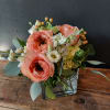 Peach roses and white flowers arranged in a square glass vase