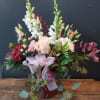 Mixed bouquet with pale pink and white flowers in a glass vase