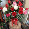 Bouquet of red, pink, and white roses with baby's breath in a glass vase