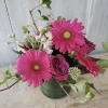 Pink gerbera daisies and roses in a green vase