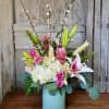 Pink lilies and roses in a blue vase with white hydrangeas