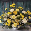 Yellow and white mixed flower arrangement in a white vase