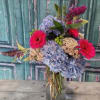 Bouquet of blue hydrangeas and bright pink gerbera daisies in a glass vase
