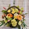 Floral wreath with mixed blooms in yellow, peach, pink, and white